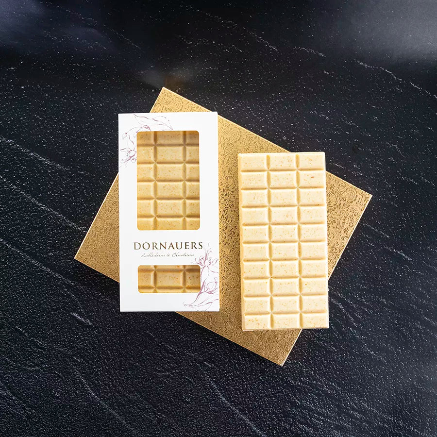 DORNAUERS Grand Cru Schokolade weiße 36 % Karamell und die Verpackung auf einer goldenen Platte