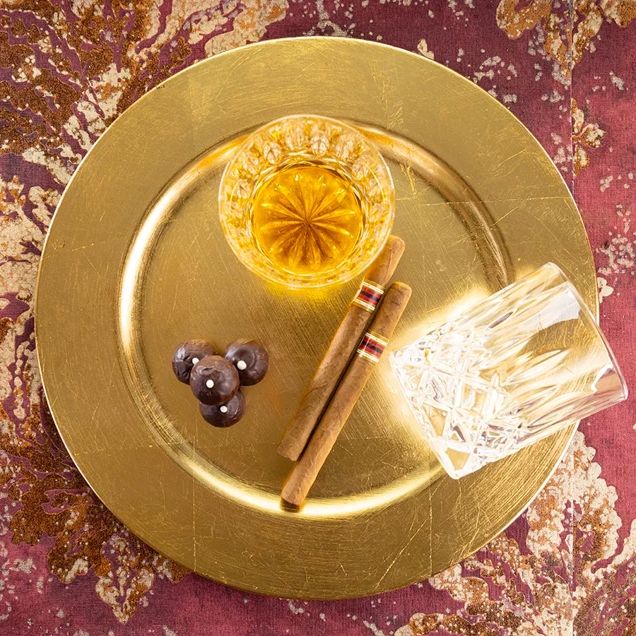DORNAUERS Grand Cru Pralinen Rum auf einem goldenem Teller, daneben Zigarren und Rumgläser  