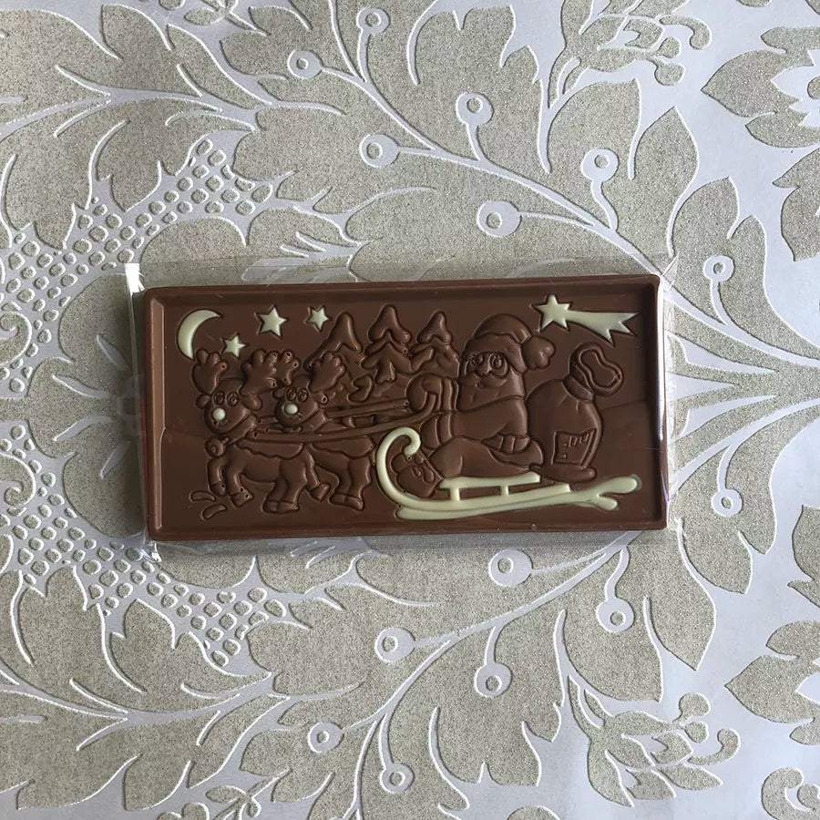 Dornauers Weihnachtstafel Vollmilch mit Weihnachtsmann im Schlitten und Rentieren Motiv, verziert mit weißer Schokolade